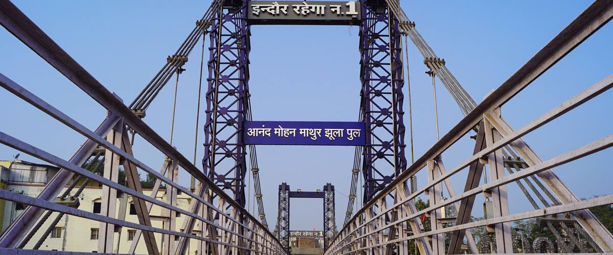A bridge with two towers and a sign in Hindi.