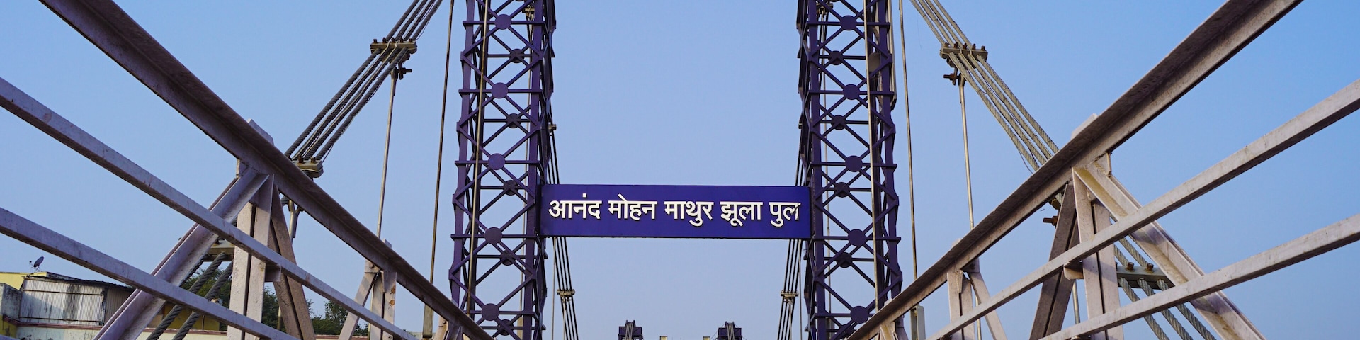 A bridge with two towers and a sign in Hindi.