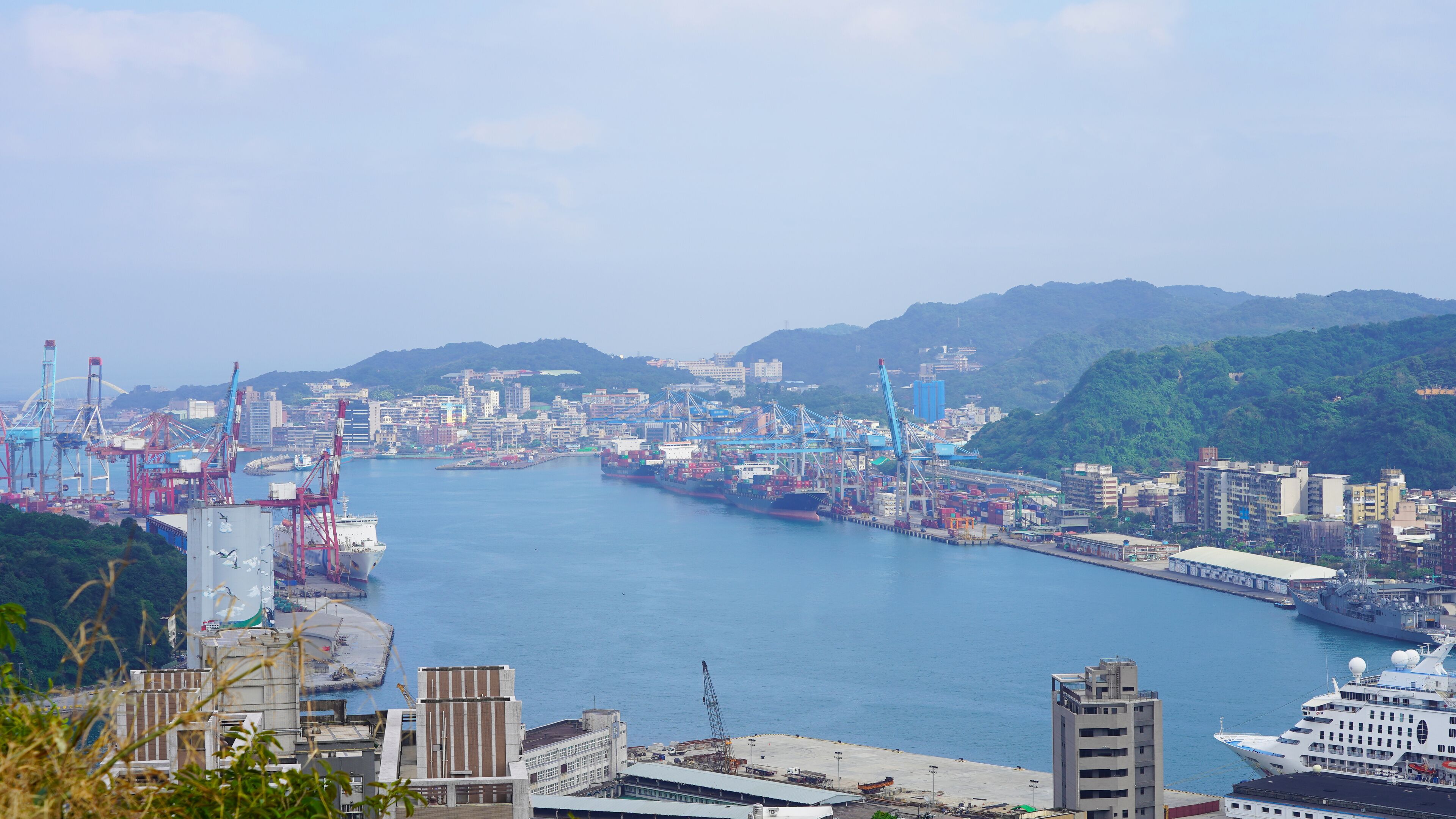 View of the passenger and cargo port in Taiwan. Panorama of the Asian port city. blue water of the pacific ocean in the bay of keelung. green hilly island