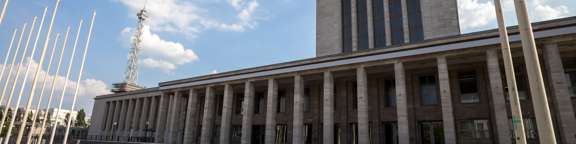 Un edificio neoclásico imponente con una torre destacada y columnas.