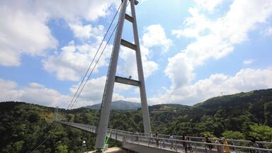 A suspension bridge with a mountainous landscape in the background.