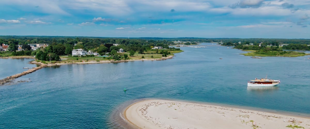 Antique boat sailing around Sandy Point, a sandspit harbor in Stonington, Connecticut, United States.