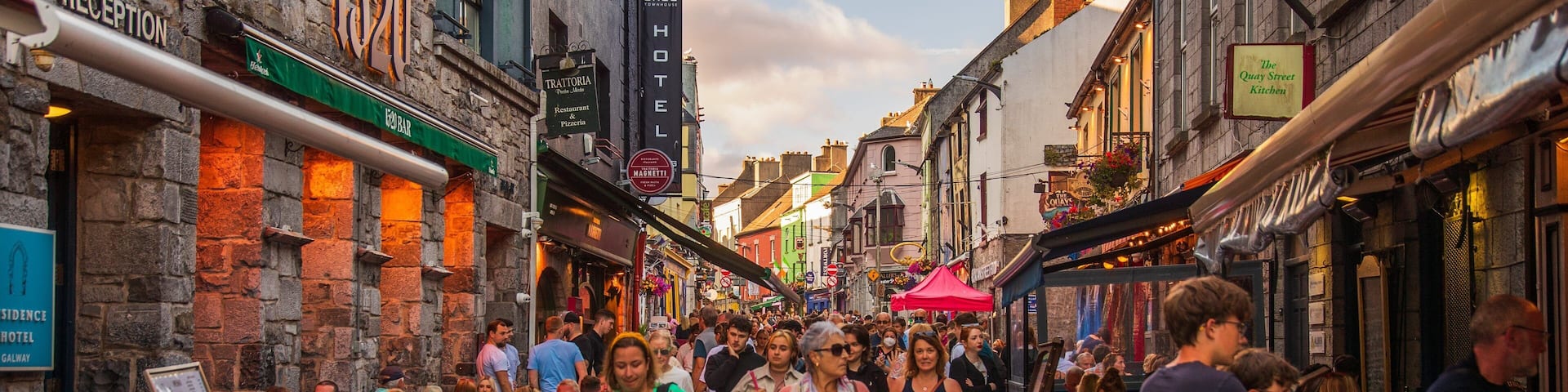 A crowded street lined with historic buildings, a reception area, and a bar.
