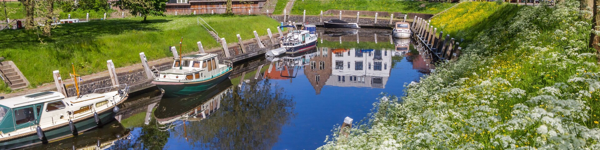 Un canal con barcos, un puente y casas a lo largo del agua.