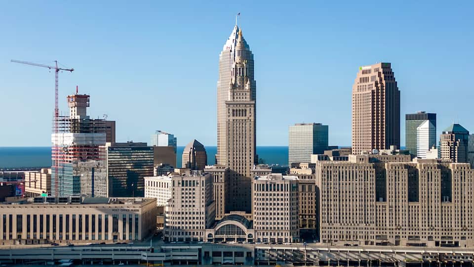 A city skyline with prominent buildings including a tall skyscraper and a historic building with a spire.