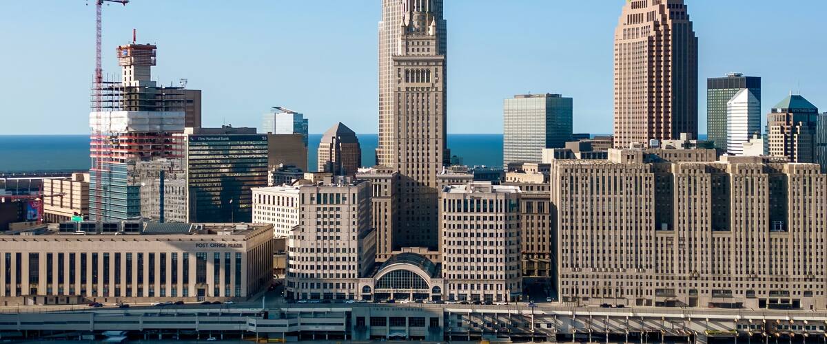A city skyline with prominent buildings including a tall skyscraper and a historic building with a spire.