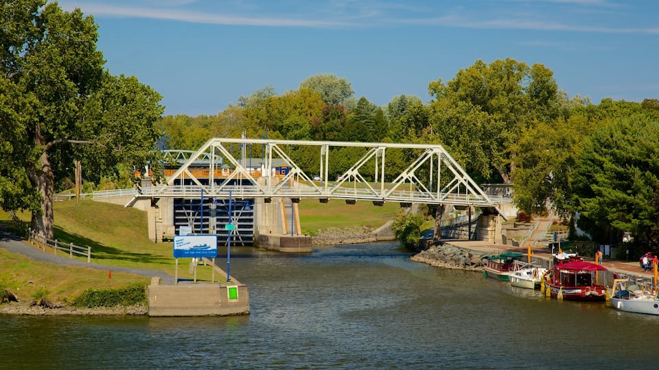 A bridge over a river with boats docked on the right.