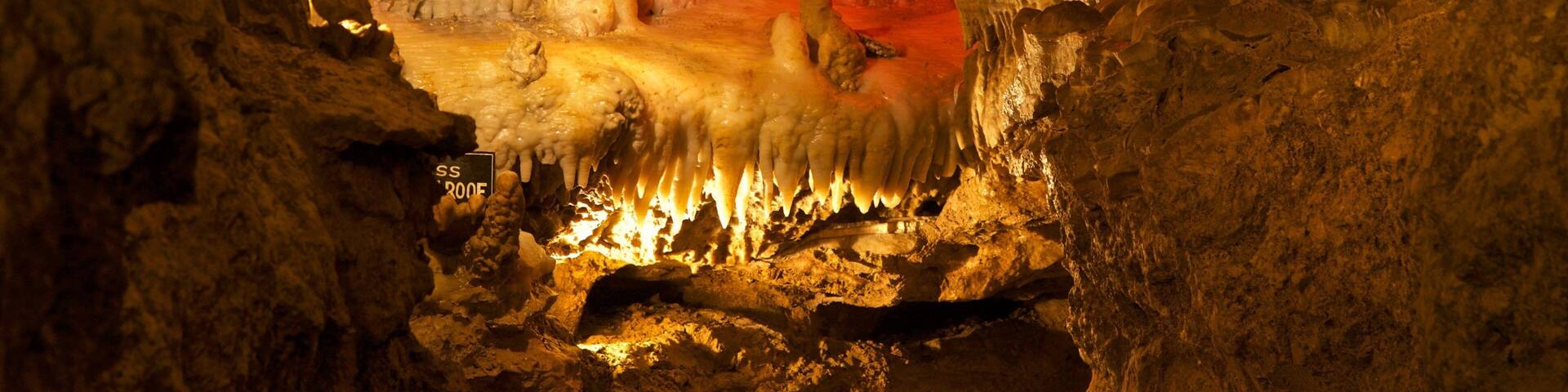 A cave with red-lit stalactites and stalagmites.