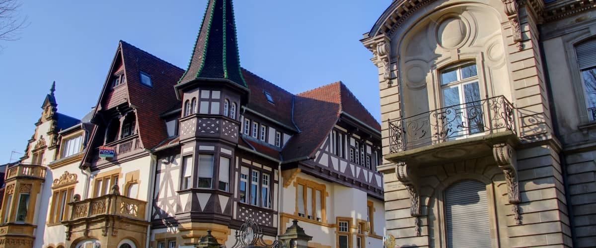 A historic building with a pointed tower and ornate balconies.