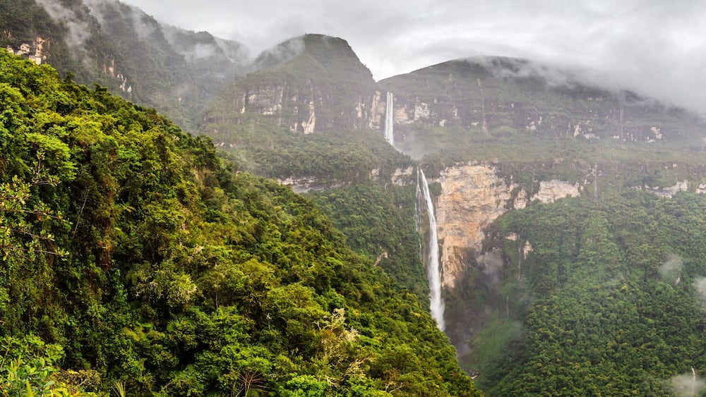 Ein üppiges, grünes Tal mit einem Wasserfall, der einen Felsen hinabstürzt.