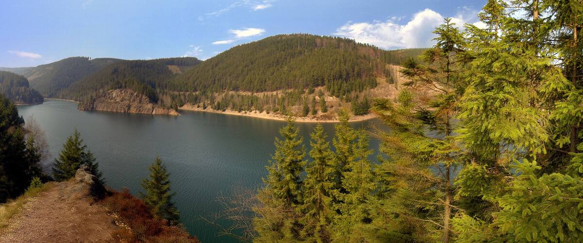 A lake surrounded by dense forests and hills.