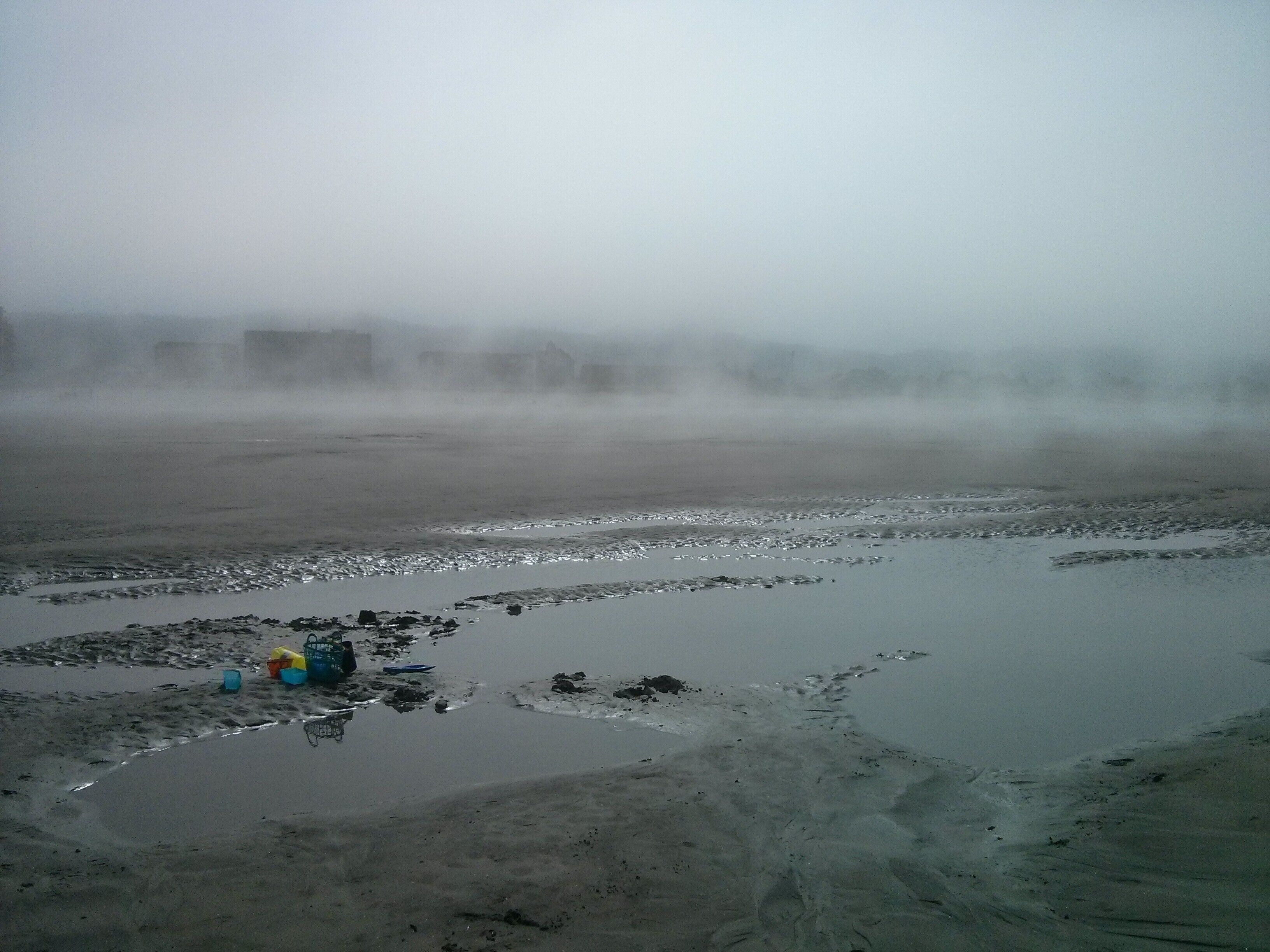 A foggy day on the beach, looking back at the line of hotels 