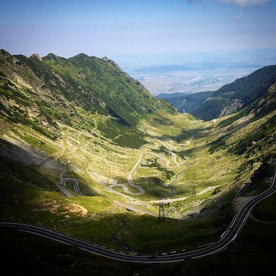 A mountainous landscape with winding roads and a valley.