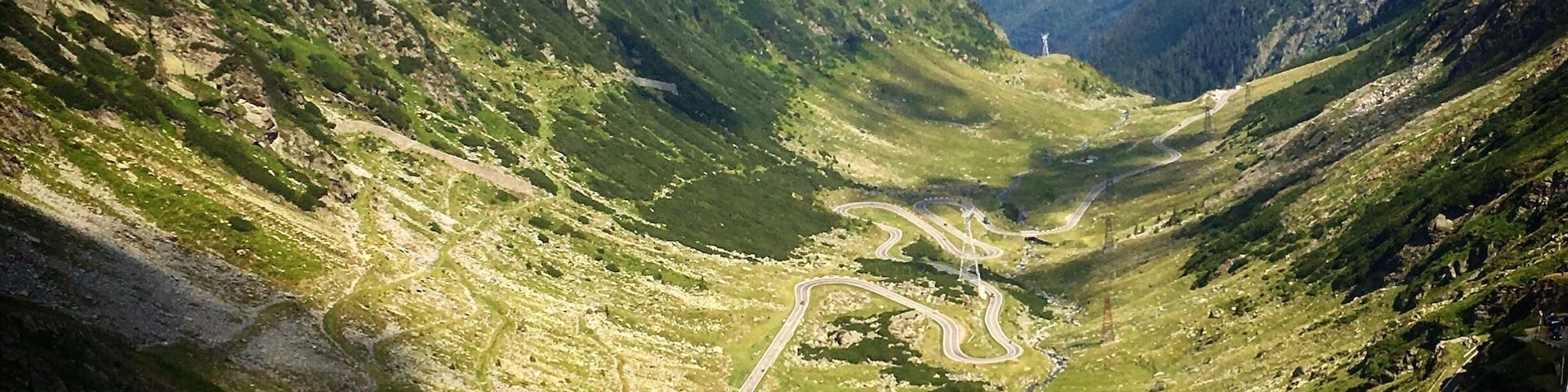 A mountainous landscape with winding roads and a valley.