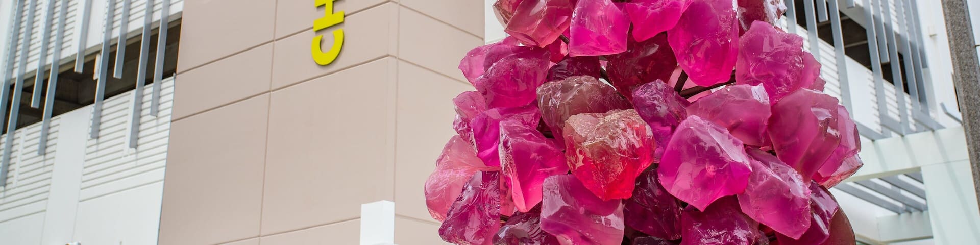 A building with a sign reading "CHICX COLLEGE" and a decorative column of pink crystals.