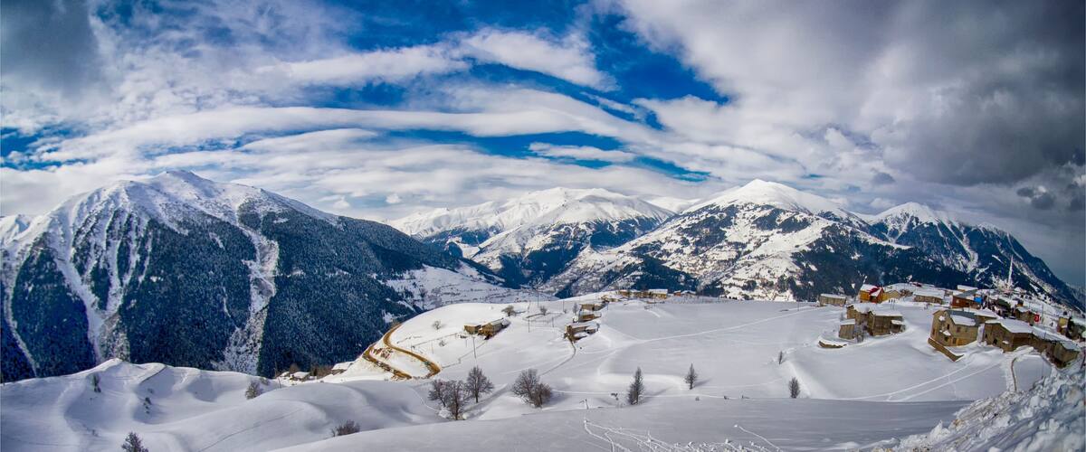 A snow-covered mountain range with a village nestled in the valley.