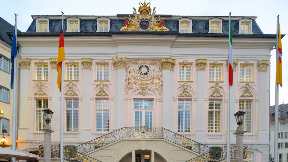 Ein prachtvolles Gebäude mit aufwendiger Goldverzierung, einer Uhr und Flaggen.