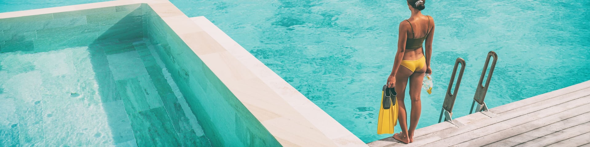 Luxury Bora Bora resort woman going snorkeling from overwater bungalow panoramic. Tahiti paradise destination vacation.