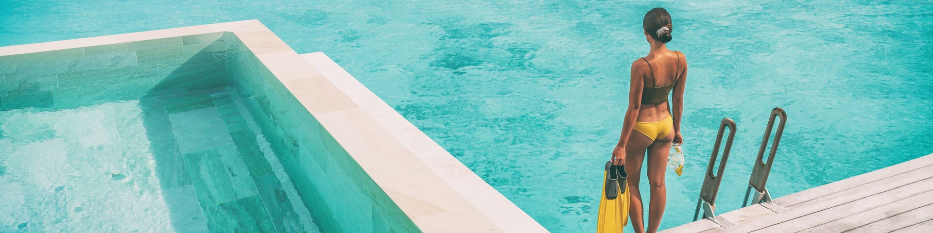 Luxury Bora Bora resort woman going snorkeling from overwater bungalow panoramic. Tahiti paradise destination vacation.