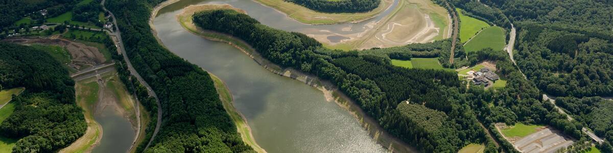 Biggevorsperre der Biggetalsperre mit Damm; links Dumicker Bach-Vorsperre; rechts Mitte am Ufer der Biggevorsperre Olper Ortsteil Eichhagen; Landesstraße 512, Bahnstrecke Finnentrop–Freudenberg; hinten links Olpe