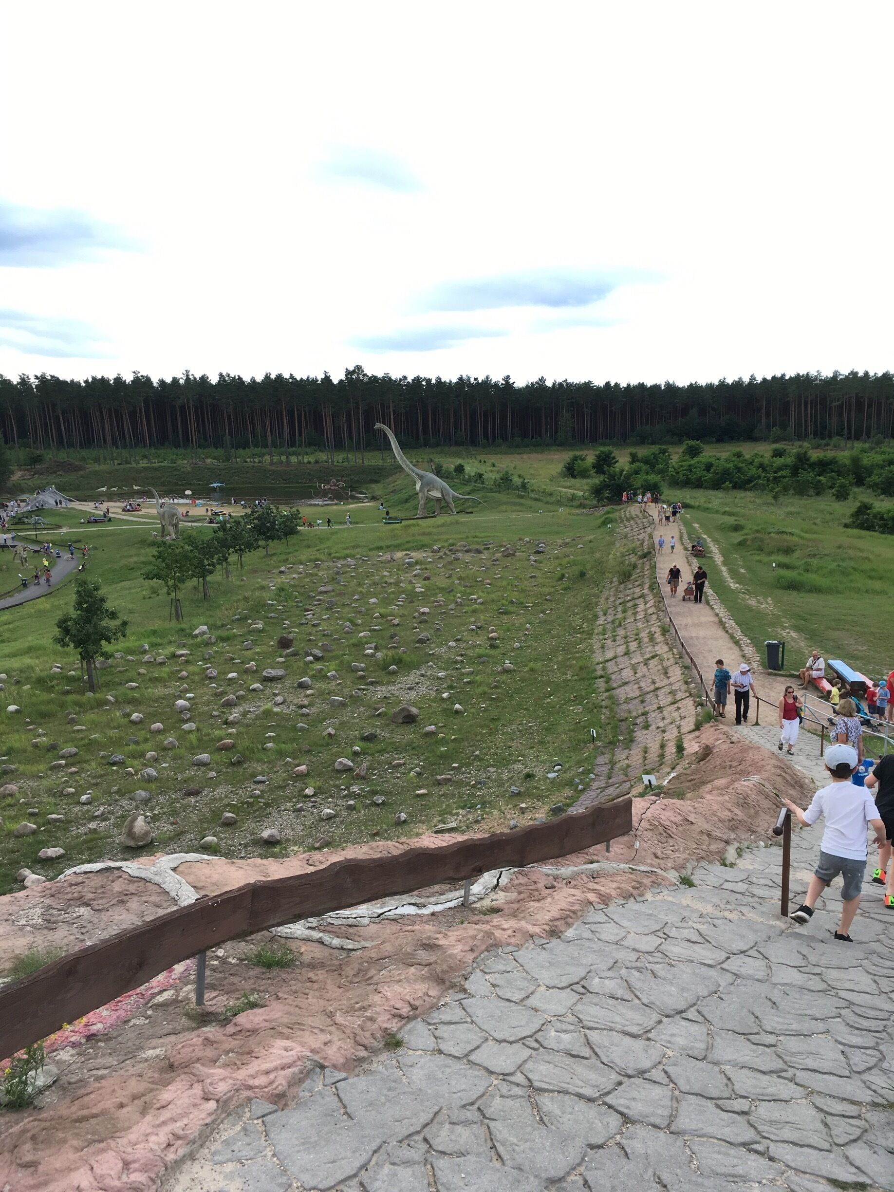A dinosaur exhibit with a large model dinosaur and a pathway for visitors.