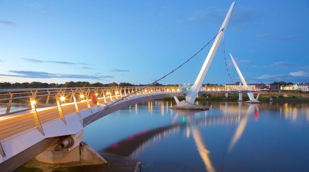 Peace Bridge ofreciendo arquitectura moderna, un atardecer y un río o arroyo