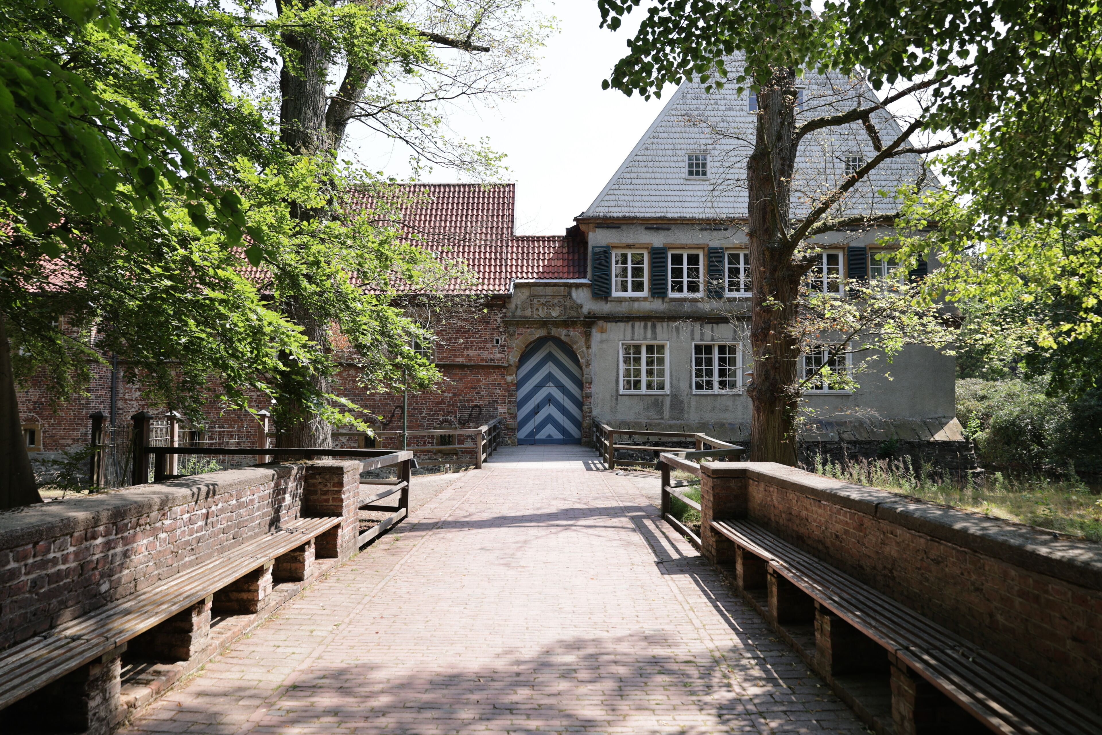 A cobblestone pathway leading to a historic building with a distinctive chevron-patterned door.