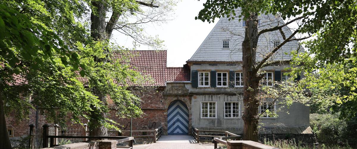 A cobblestone pathway leading to a historic building with a distinctive chevron-patterned door.