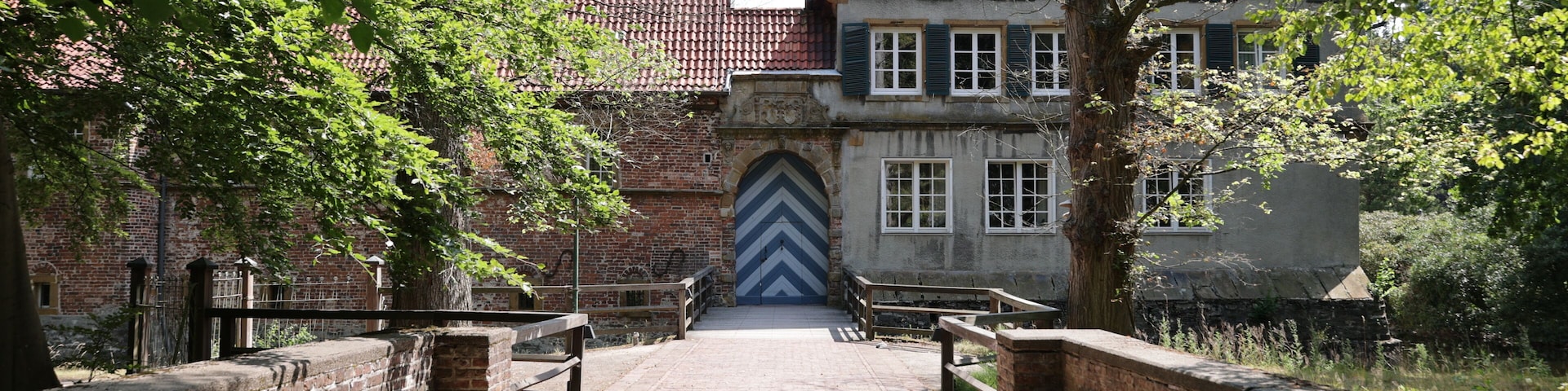 A cobblestone pathway leading to a historic building with a distinctive chevron-patterned door.