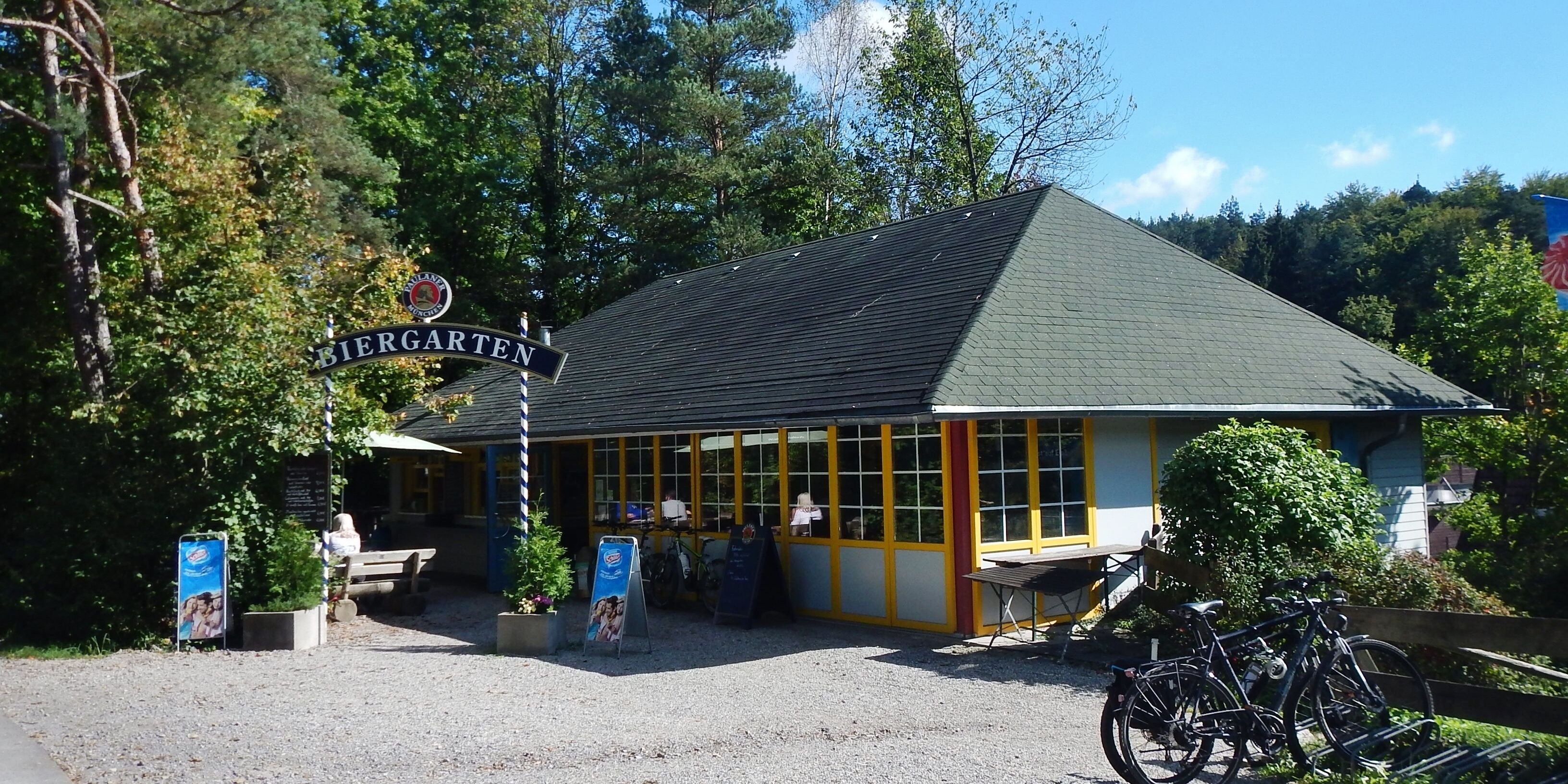 A building with a sign reading "Biergarten" and a bicycle parked in front.