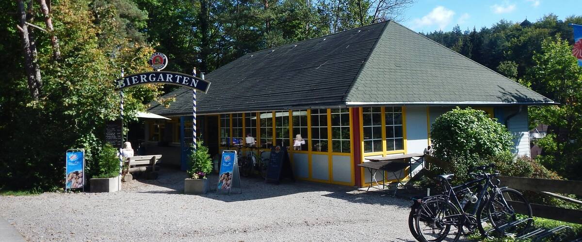 A building with a sign reading "Biergarten" and a bicycle parked in front.
