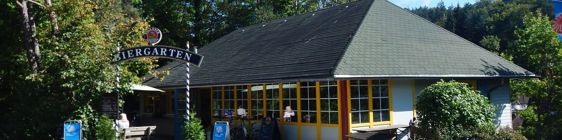 A building with a sign reading "Biergarten" and a bicycle parked in front.