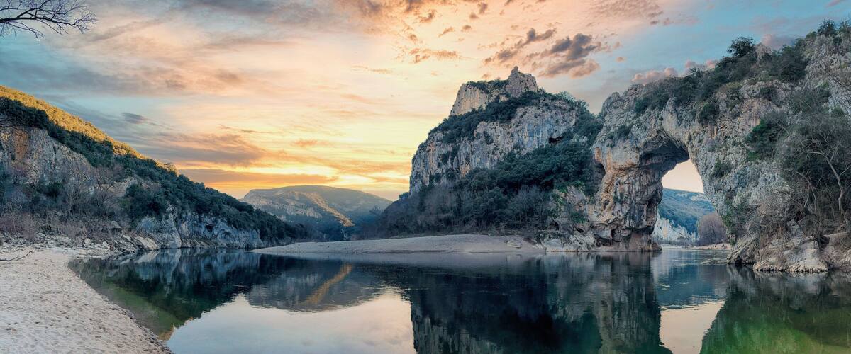 A serene river with rocky cliffs and a clear reflection.