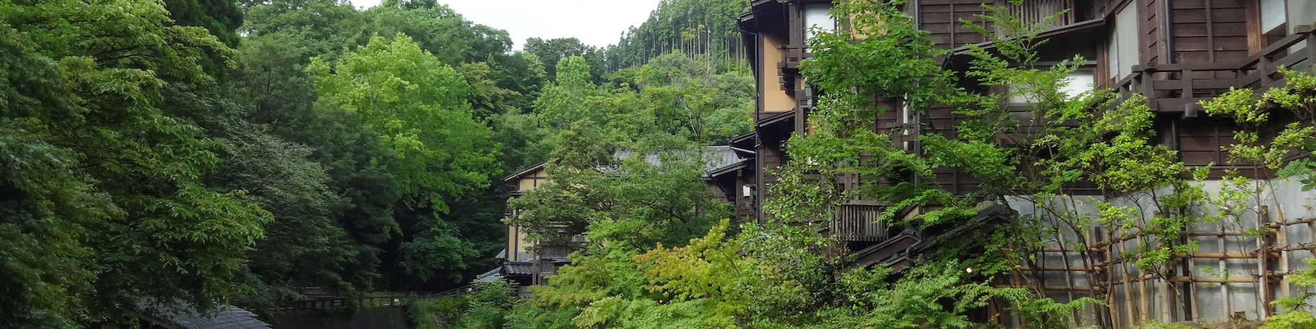 A traditional Japanese village with wooden houses and a flowing river.