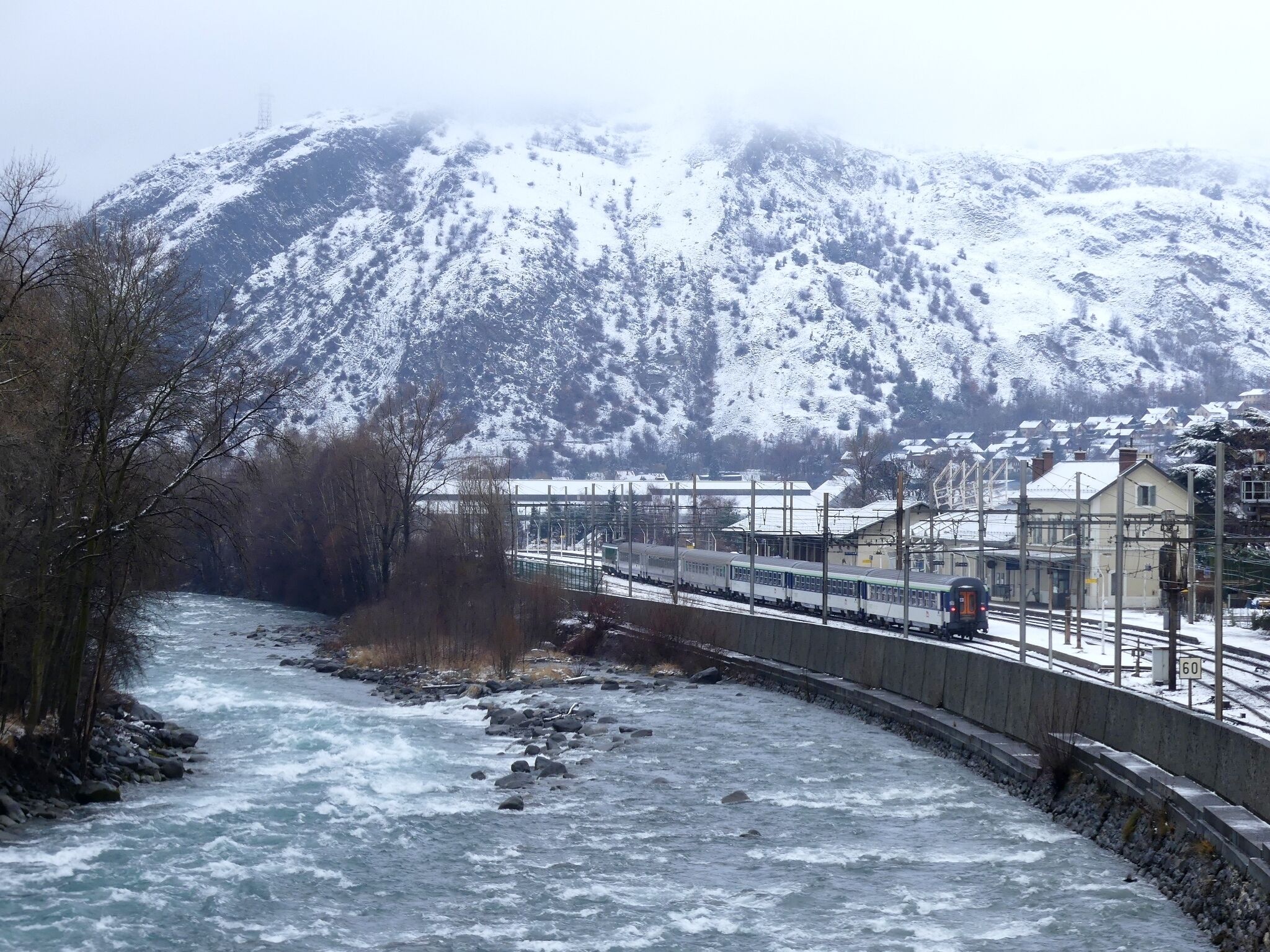 Sight of the Arc river crossing Saint-Michel-de-Maurienne in the snow-covered Maurienne valley in Savoie, France.