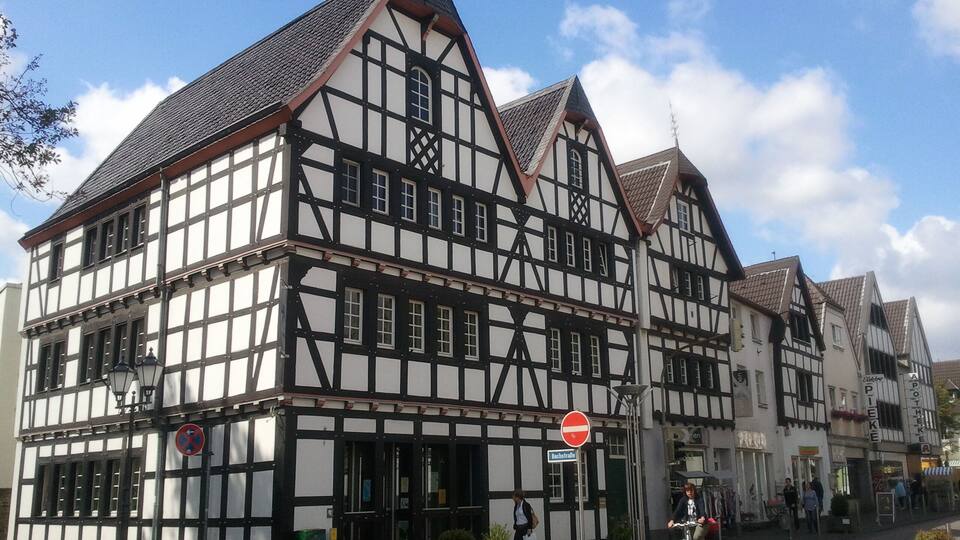 A traditional half-timbered building with a steeply pitched roof and a 'no entry' sign.