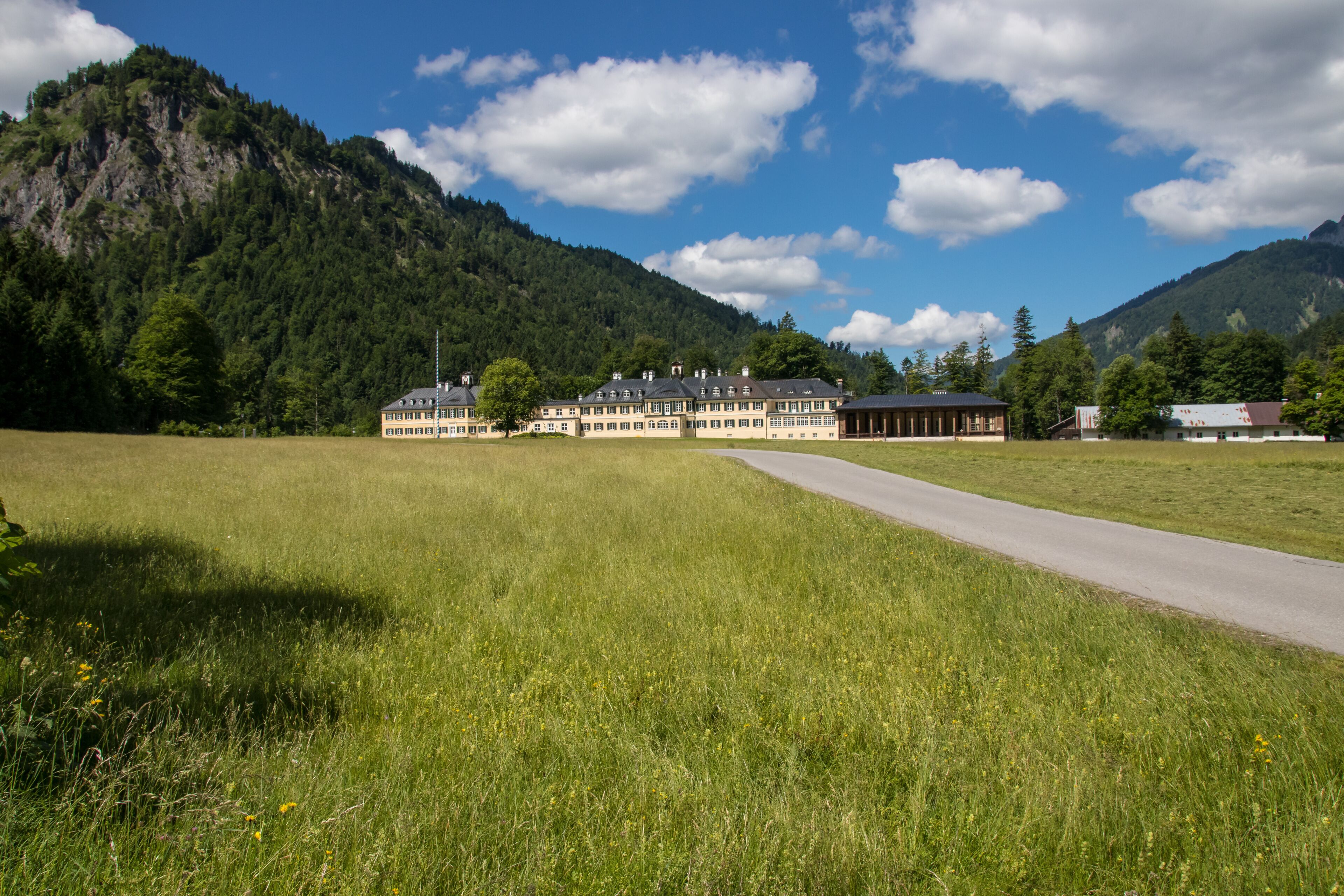 A mountain landscape with a large building and a road.