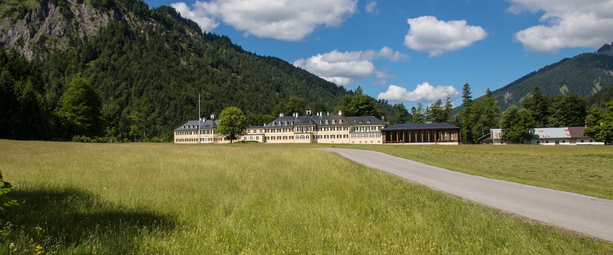 A mountain landscape with a large building and a road.