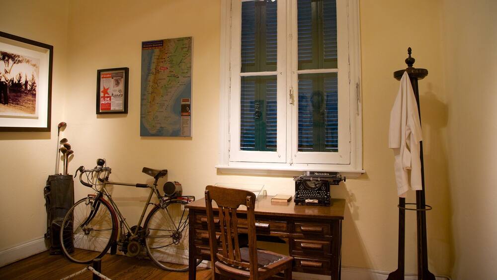 A room with a bicycle, a map, a typewriter, and a chair.