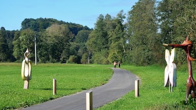A winding path through a green field with two large sculptures on either side.