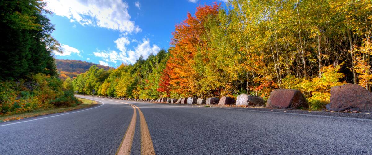 Autumn daytime view of a mountain road in Lake George, NY on Prospect Mountain, Adirondack State Park, with trees changing color.