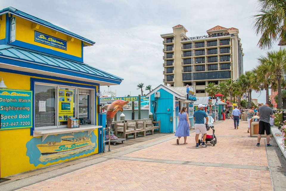 A colorful Sea Screamer building with a speed boat and dolphin watch sign.