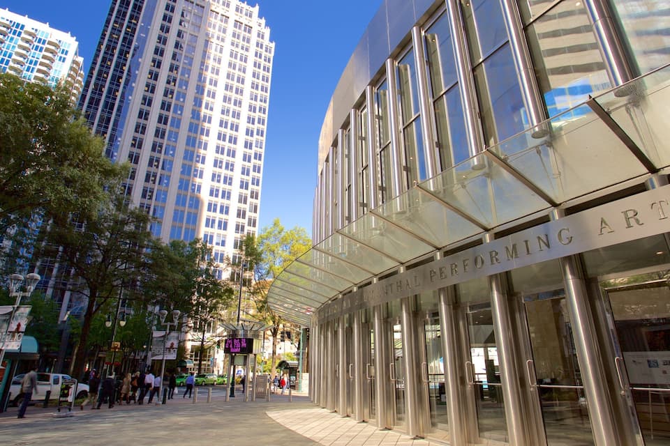 A modern building with a glass facade and a sign that reads "Performing Arts."