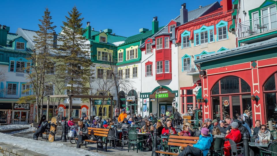 Mont-Tremblant Pedestrian Village showing outdoor eating and street scenes as well as a large group of people
