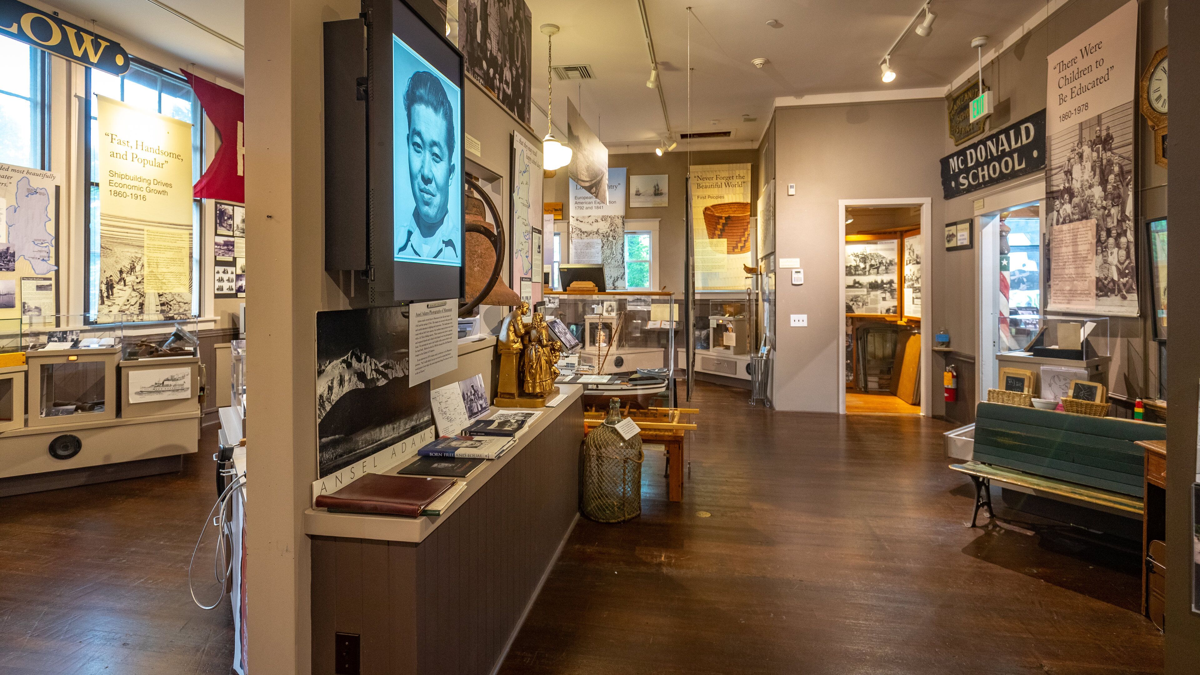 A museum interior with historical exhibits, including a Donald School sign, and various informational displays.