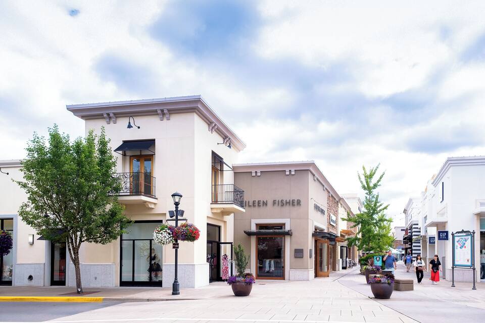 A shopping street with a green fish restaurant and a Gap store.