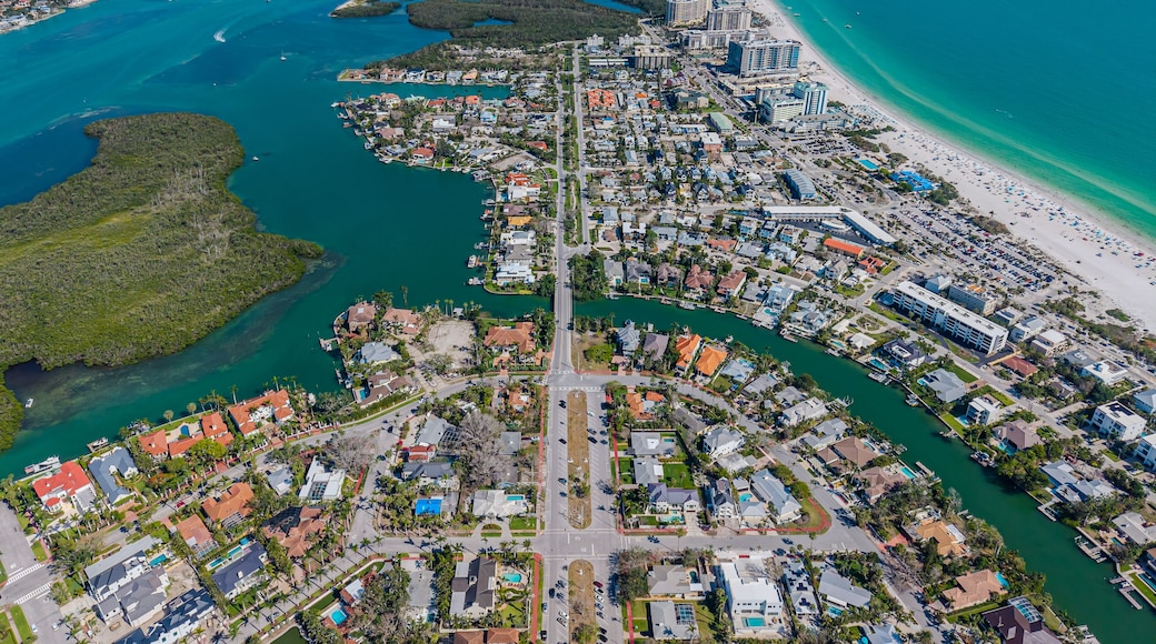 An aerial view of a coastal city with a dense urban area, a long beachfront, and a network of waterways.
