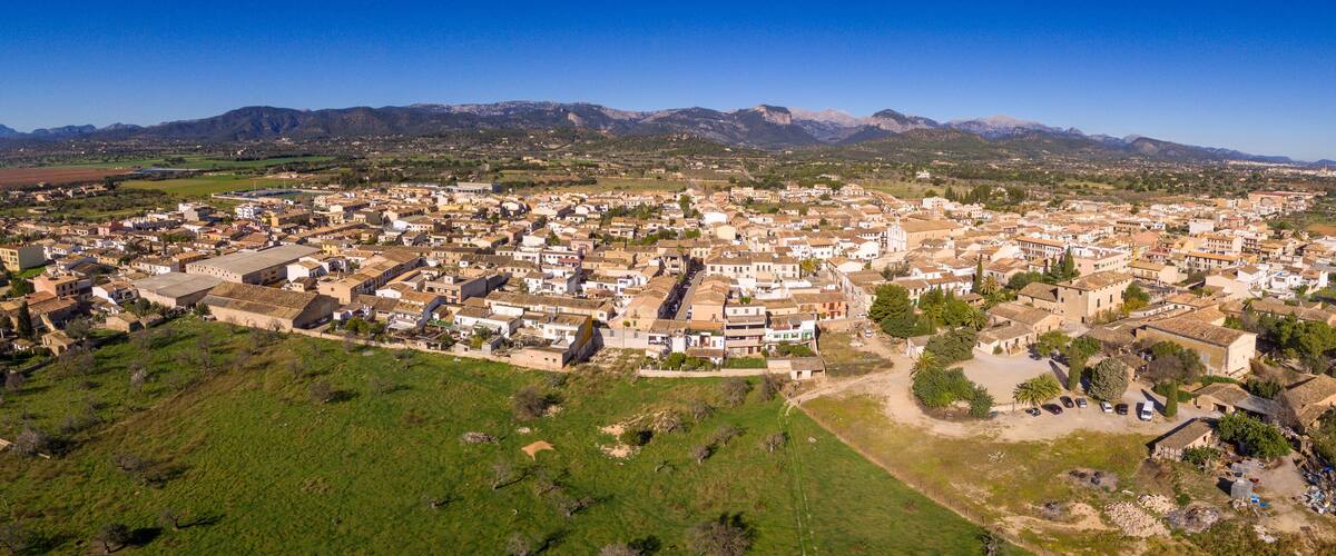 An aerial view of a town with a mountainous backdrop.