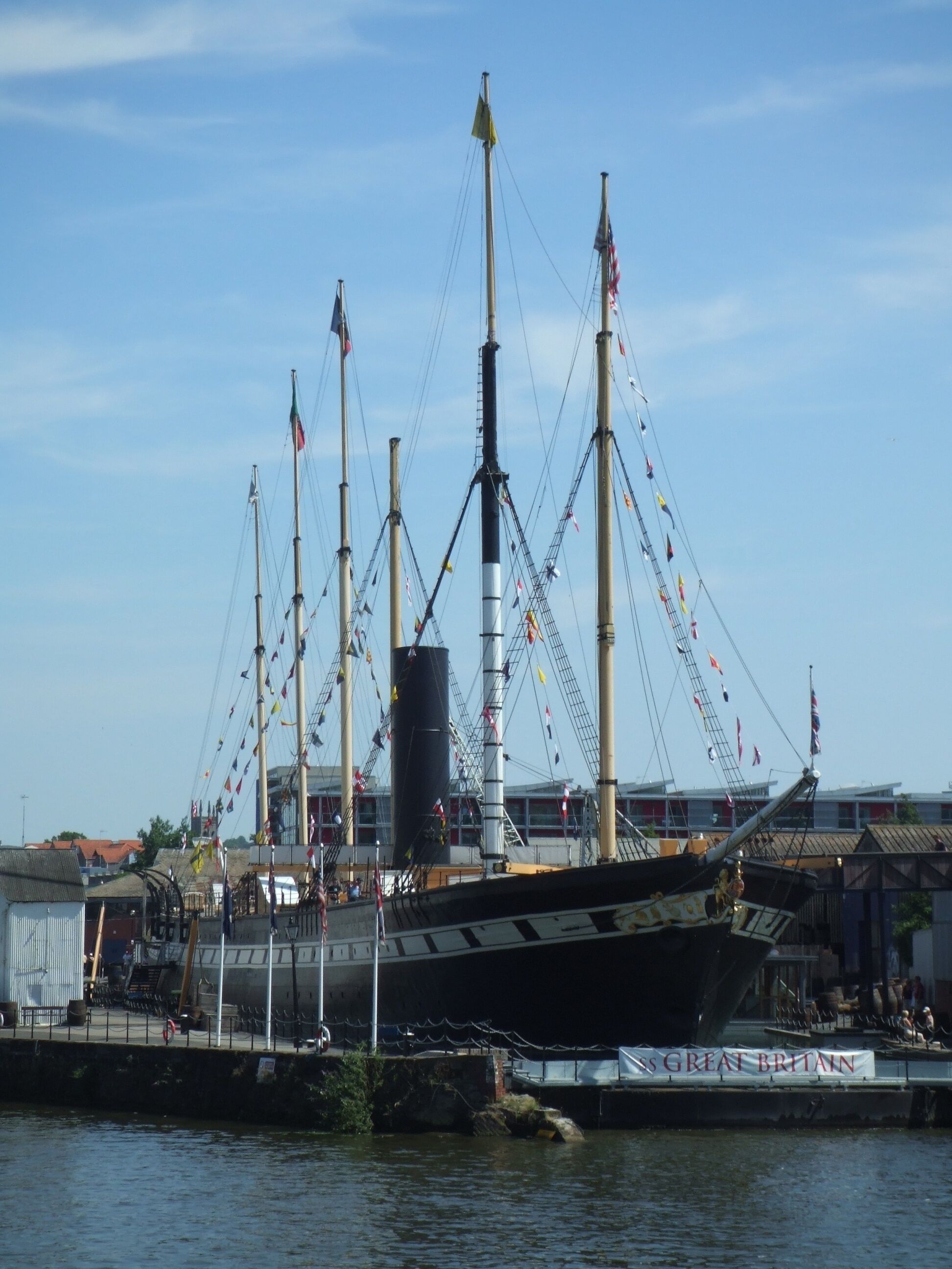Un grand voilier était amarré dans un port, arborant de nombreux mâts et des drapeaux.