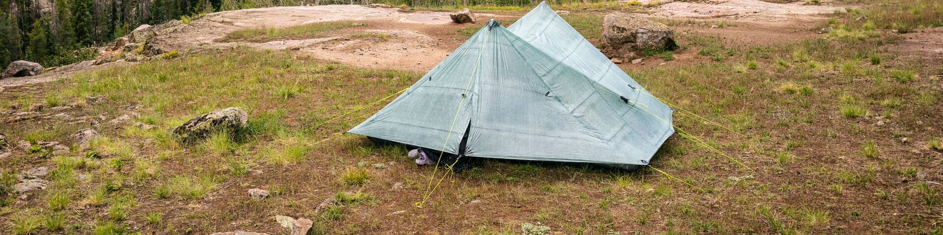 Tent set up in a scenic mountainous forest area